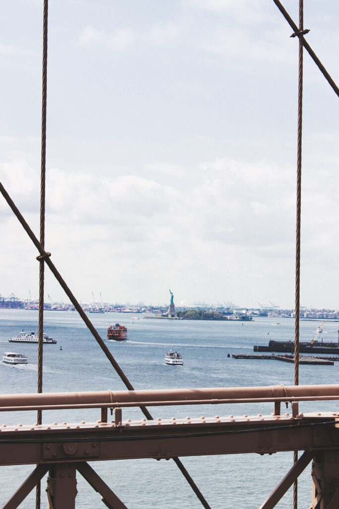 Bild in Hochformat von der Freiheitsstatue. Fotografiert durch die Seile der Brooklyn Bridge. Aus dem Artikel New York Reise 2019