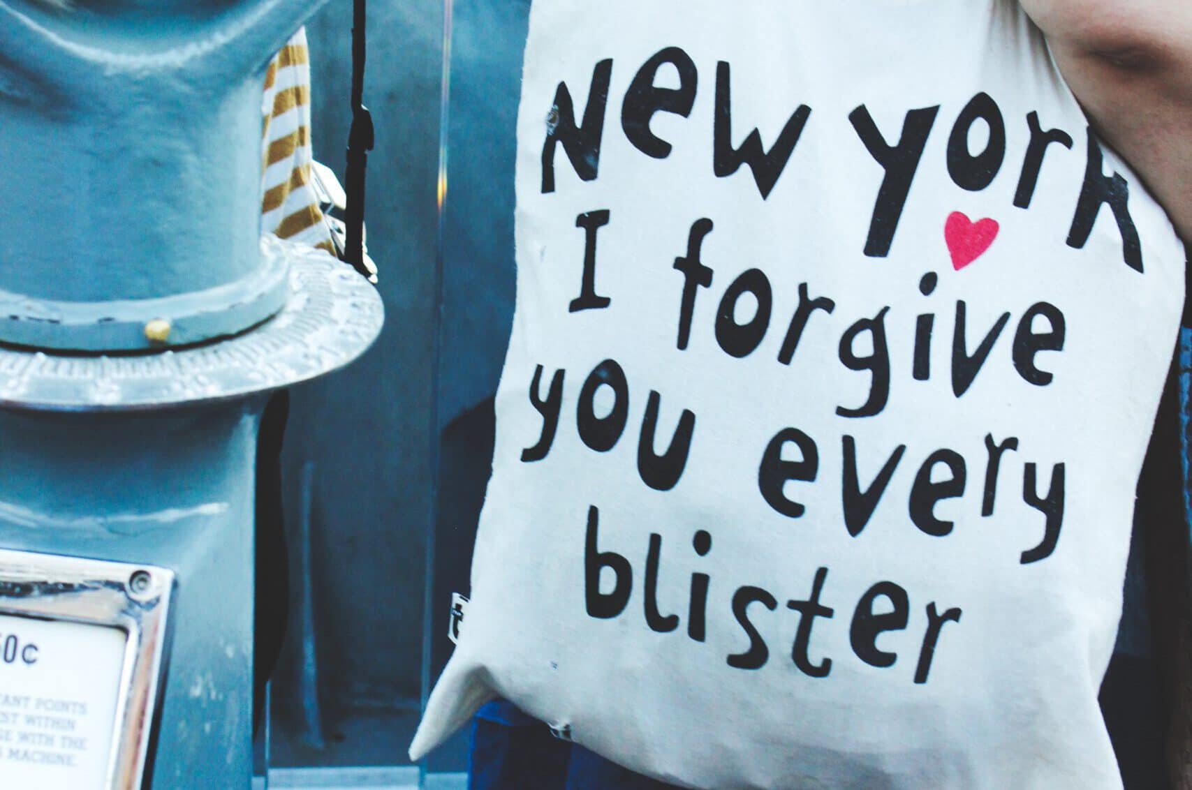 Bild von Frau die Souvenir Beutel mit Aufschrift "New York i forgive you every Blister" trägt. Aus dem Artikel New York Reise 2019