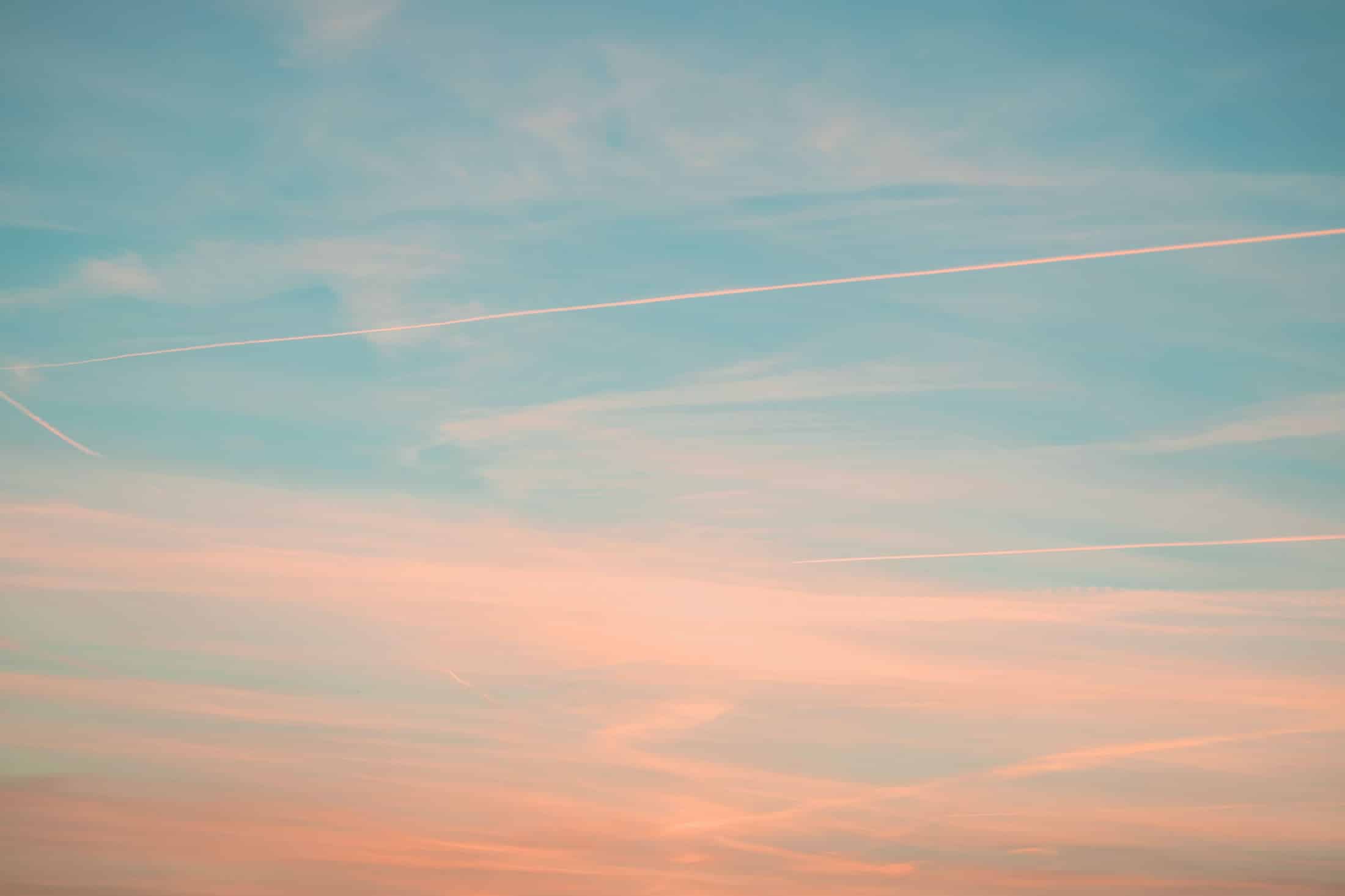 Himmel in Farben des Sonnenuntergangs mit Flugzeugstreifen