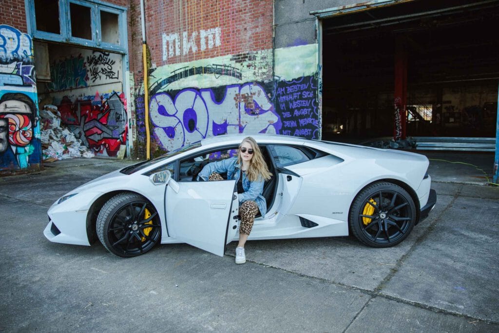 Eine Junge Frau sitzt mit Sonnenbrille und offenen Haaren in einem weißen Lamborghini - Aus dem Artikel: 27 Dinge, die ich letztes Jahr gelernt habe