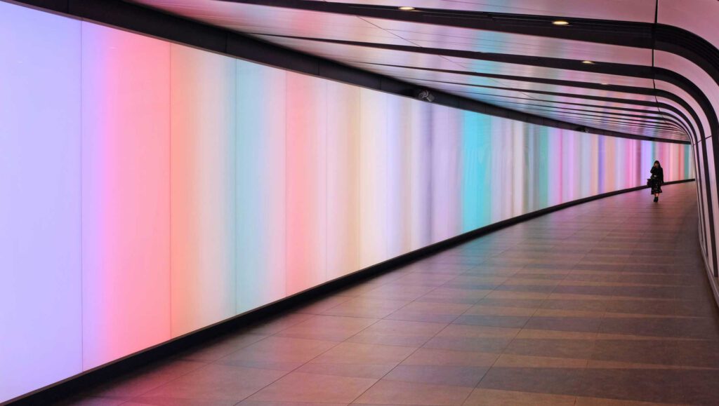 Bild eines Tunnels mit Bildschirmen als Wänden die einen pastelverlauf zeigen. Aus dem Artikel: ADHS Awareness Month – für dich ein Monat, für mich 12