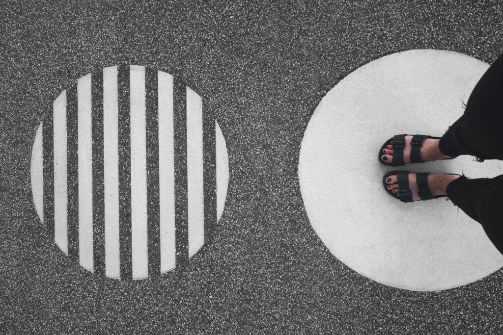 Füße einer Frau die in einem weißen Kreis steht, der auf Asphalt gemalt ist.Aus dem Artikel: ADHS Awareness Month – für dich ein Monat, für mich 12